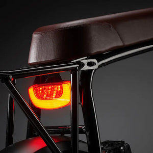 Close-up of the integrated rear LED tail light tucked under the brown bench seat of the Rocket 88S.