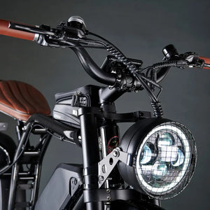 Detailed shot of the round LED headlight on the Rocket SX protected by a black metal mesh grill guard.