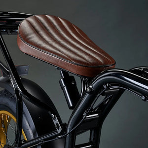 Close-up of the coil-spring suspension shock absorber located under the brown leather seat of the Rocket SX e-bike.