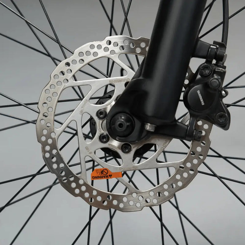 Close-up of the Shimano disc brake rotor and caliper on the front wheel of the Mark2 X-Cross 520.