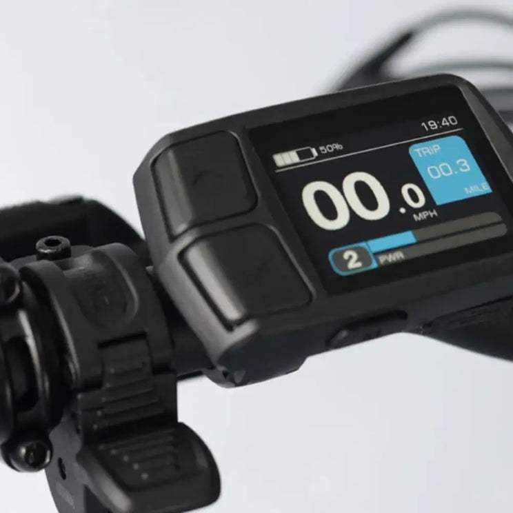 Close-up of the Wisper e-bike's LCD display showing current speed (00.0 MPH), battery level, assist level, and trip mileage.